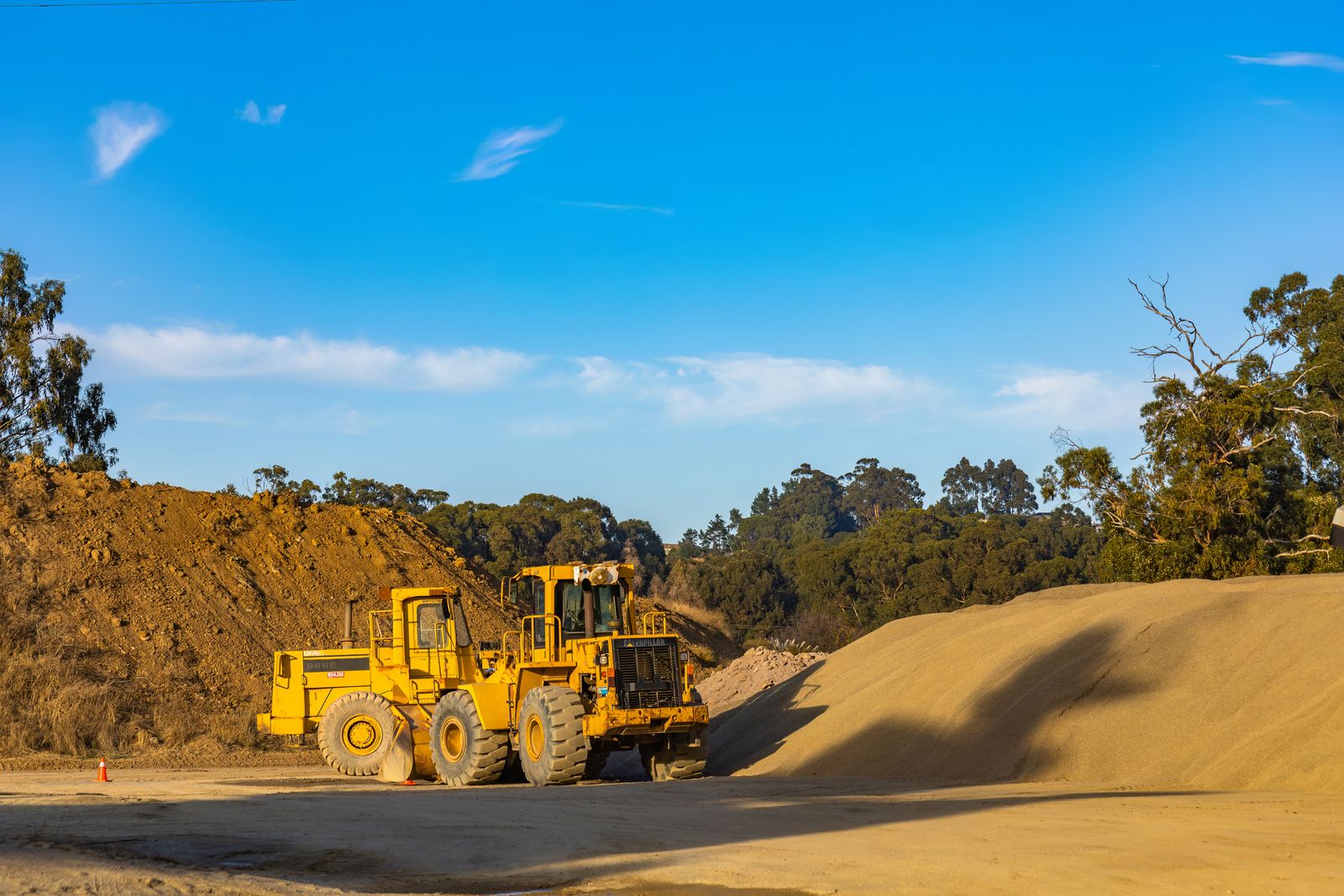 Front loader on a cleared earthworks site among gum trees